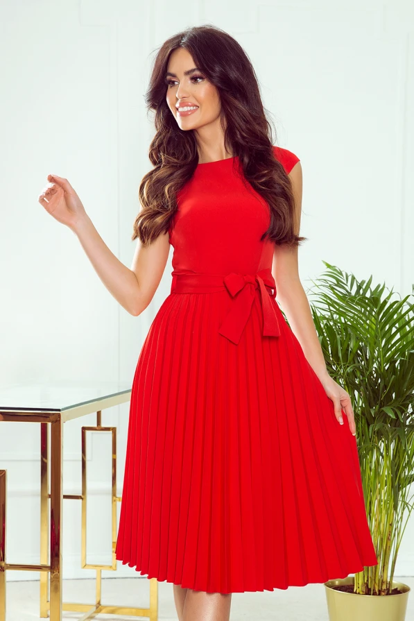 Na zdjęciu znajduje się lila plisowana sukienka, która charakteryzuje się eleganckim krojem i delikatnym plisowaniem. Sukienka lila plisowana ma klasyczny fason z wiązaniem w talii, co dodaje jej szyku i kobiecości.