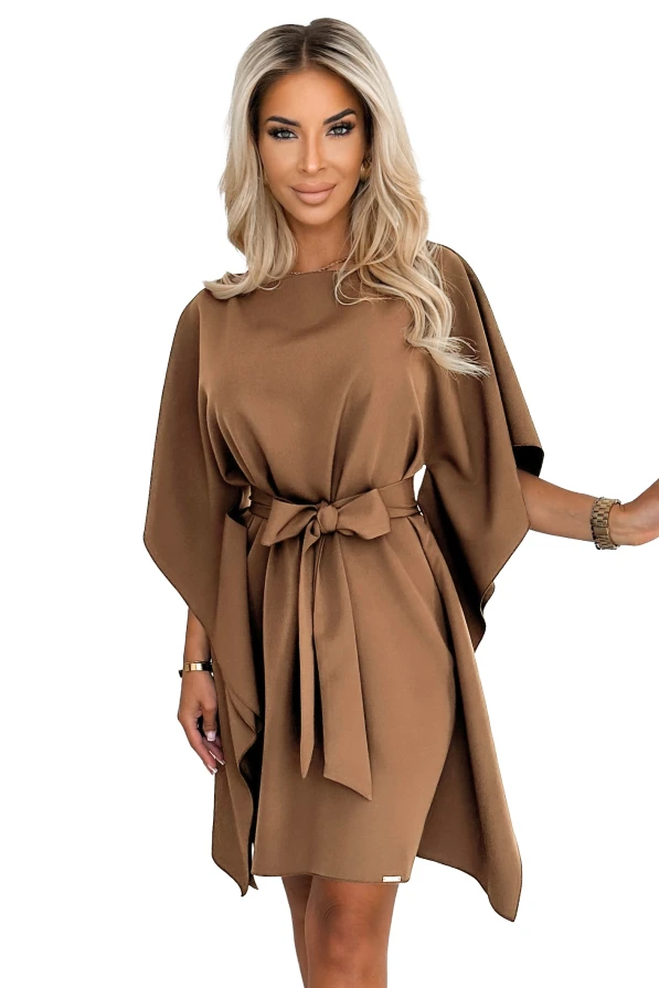 Modelka prezentuje stylową sukienkę Numoco z szerokimi rękawami i paskiem w talii w odcieniu karmelowym – modna kreacja polskiej produkcji.