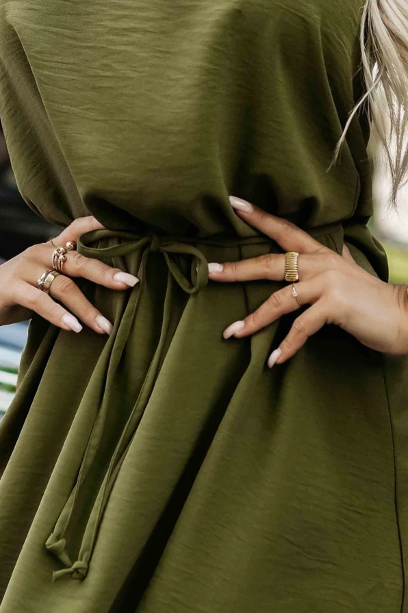 Modelka w zielonej sukience Victoria o trapezowym kroju, uszytej z kreszowanego materiału, idealnej na codzienne stylizacje – Numoco, polski producent.