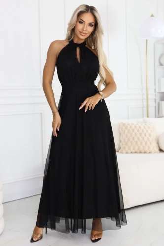 Modelka w **czarnej, długiej sukience tiulowej** z **dekoltem halter** i małym wycięciem typu **łezka**, z podkreśloną talią i zwiewnym, rozkloszowanym dołem.}