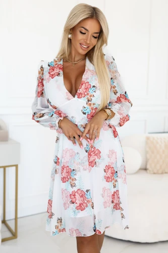 Modelka prezentuje zwiewną kopertową sukienkę w kwiaty z długim, transparentnym rękawem i głębokim dekoltem; lekka, romantyczna stylizacja idealna na wiosnę i lato, produkt polski marki Numoco.}