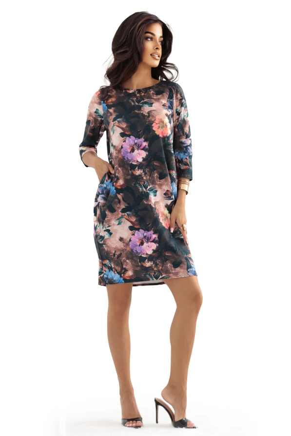 Modelka prezentuje czekoladową sukienkę oversize w kwiaty z kieszeniami marki Numoco, limitowaną edycję polskiej produkcji, idealną na co dzień i wyjątkowe okazje.