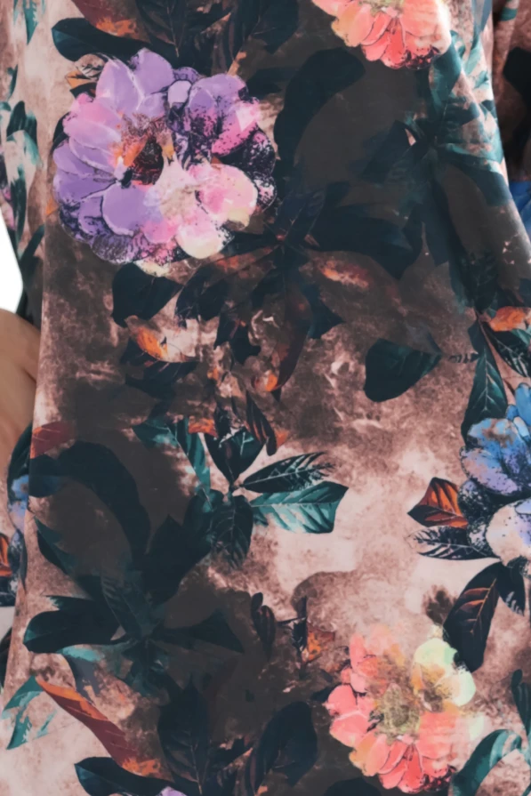 Modelka prezentuje czekoladową sukienkę oversize w kwiaty z kieszeniami marki Numoco, limitowaną edycję polskiej produkcji, idealną na co dzień i wyjątkowe okazje.