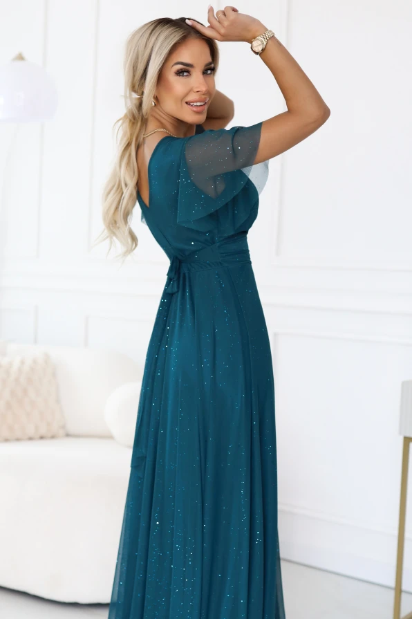 Modelka prezentuje długą sukienkę koktajlową MELANIA w kolorze butelkowej zieleni, idealną na wesele i eleganckie przyjęcia.