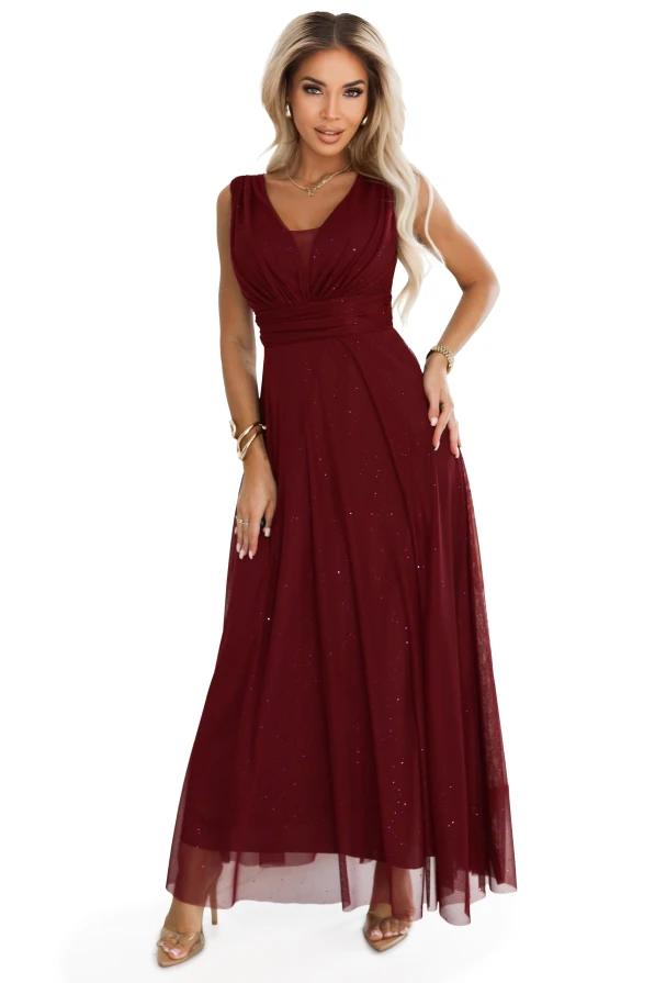 Modelka prezentuje długą bordową sukienkę wieczorową Numoco Basic z dekoltem V i subtelnym brokatowym połyskiem