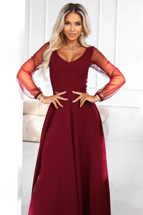 Elegancka długa bordowa suknia wieczorowa na modelce – rozkloszowany dół i przezroczyste rękawy.